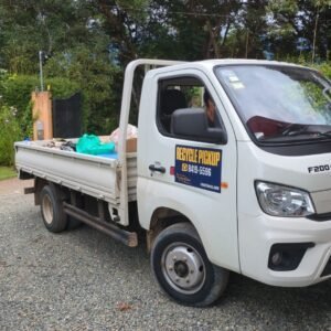 Recycling pickup truck with recycling bins and materials in the back.
